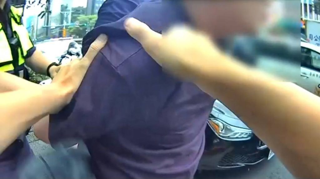 陳男情緒失控遭警上銬保護管束。（記者林金聖翻攝）