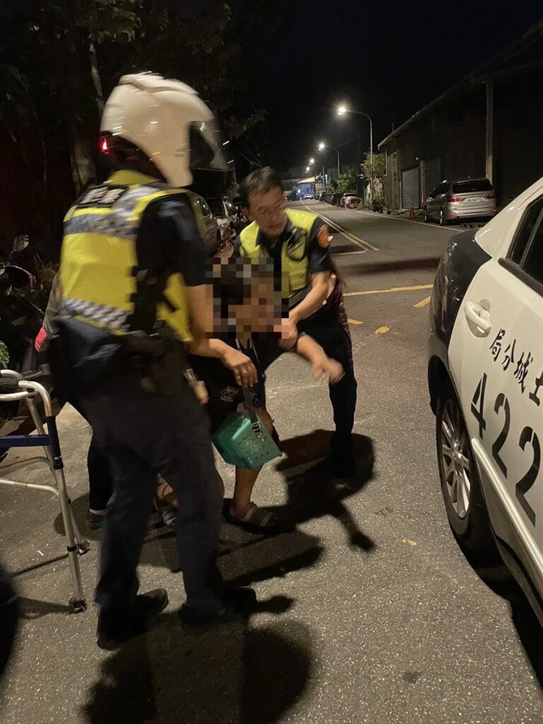 行動不便的女子跌坐在馬路中,員警立即上前將其攙扶至路邊並協助示警後方車輛