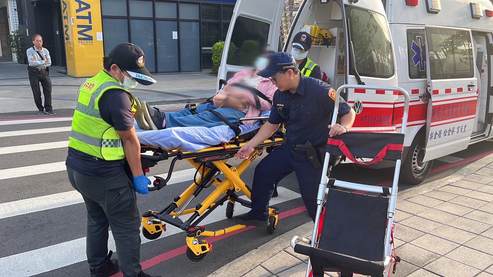 捷運警察協助將她送上救護車，前往中國醫藥大學附屬醫院接受治療。（圖/記者江雁武翻攝）