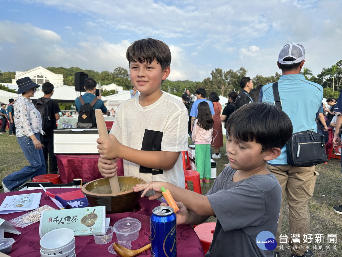 這二位混血兄弟也參與擂茶玩得開心。(記者扶小萍攝)