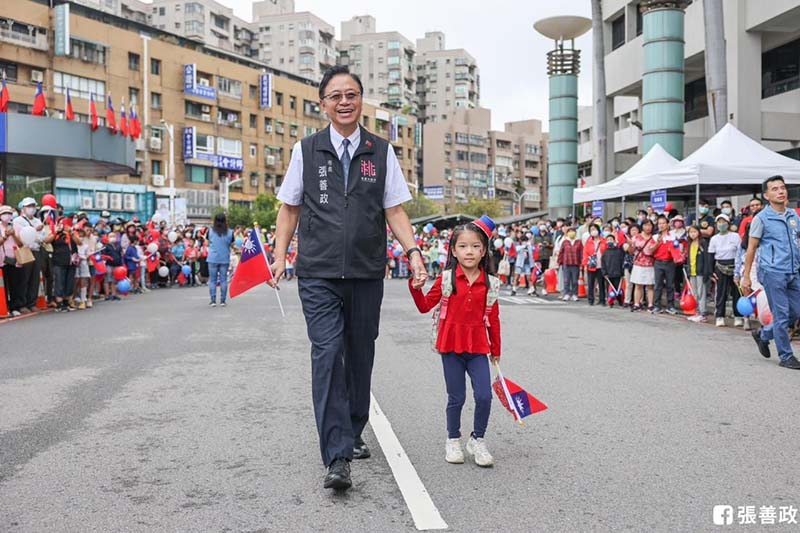 桃園市長張善政10日在市府廣場舉行升旗典禮，開心牽著小朋友的手，隔天就遭民進黨市議員炮火洗禮。圖／引自張善政臉書