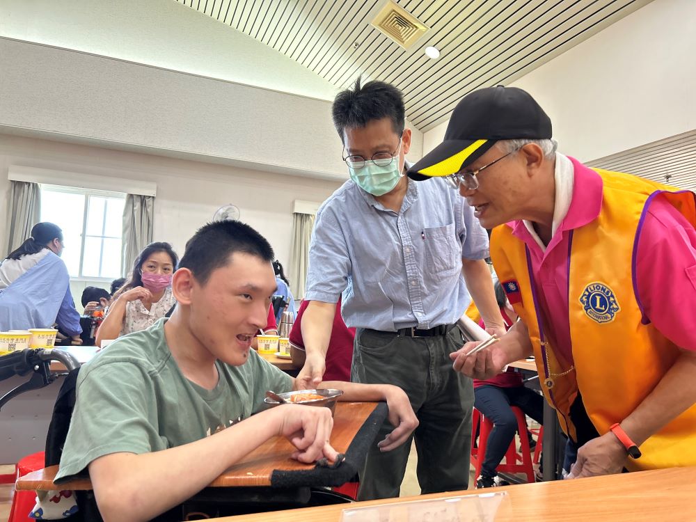 《圖說》台北市華夏獅子會會長許國安(右)和謝鑫敏院長(中)陪伴院生小丞(左)一起夾菜。〈社會局提供〉