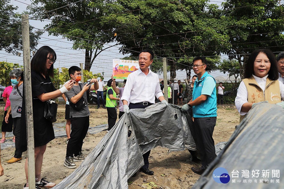 翁章梁在絲瓜棚實地示範抖落廢農膜塵土、捆好動作,宣導正確收取方式,透過抖落砂土達到再利用業者允收標準/陳致愷翻攝