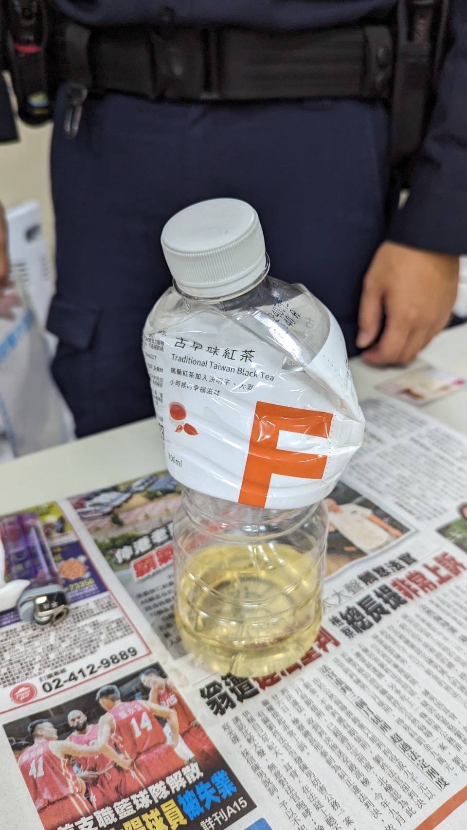 嫌犯手持裝有汽油之寶特瓶。（記者薛秀蓮翻攝)