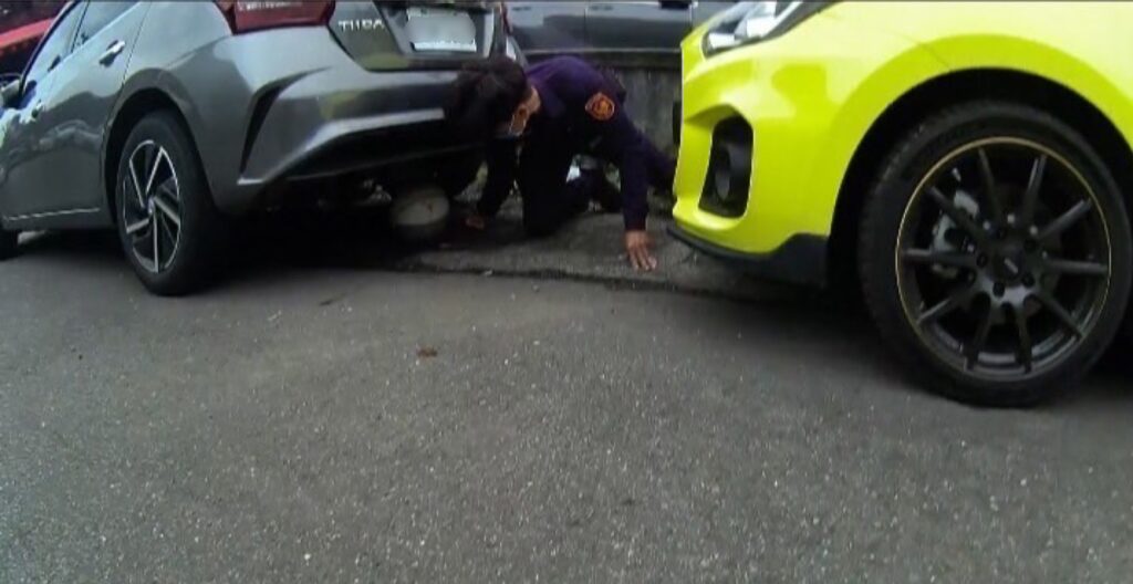 員警俯身鑽入車下取出籃球
