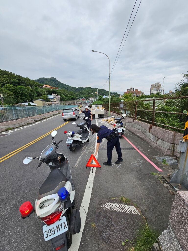 員警持指揮棒疏導交通，並向附近居民借用掃具，三名員警合力迅速於40分鐘協助清除散落於路面的磁磚碎片