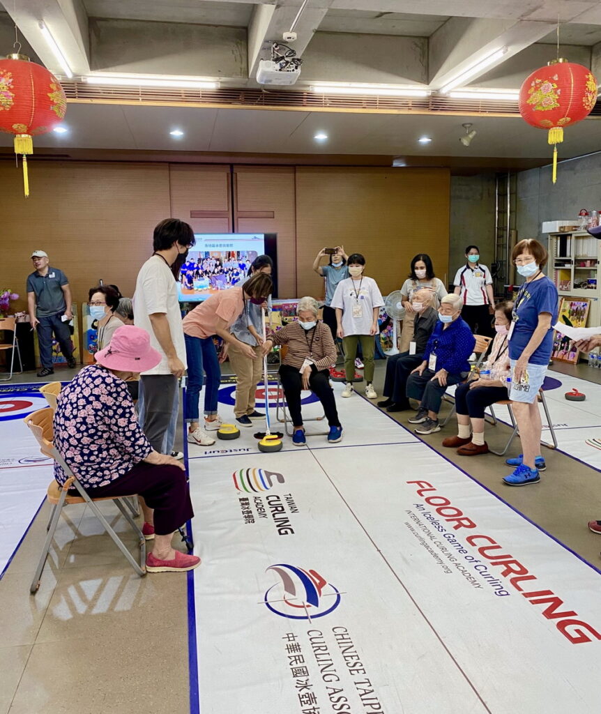 志工協助奶奶進行冰壺體驗