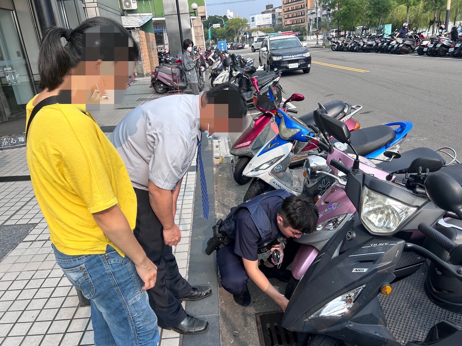 顏瑞廷副所長手持長勾蹲下三兩下成功撈起74歲老婦人的家門及機車鑰匙。（圖/記者江雁武翻攝）