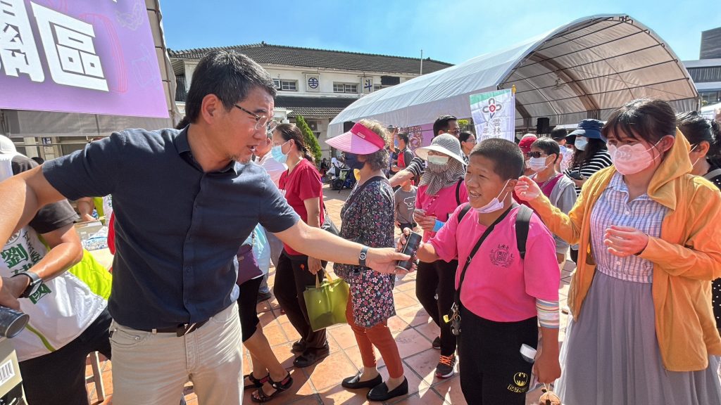 劉建國化身推銷員向民眾推銷仙草茶。(記者林金聖翻攝)