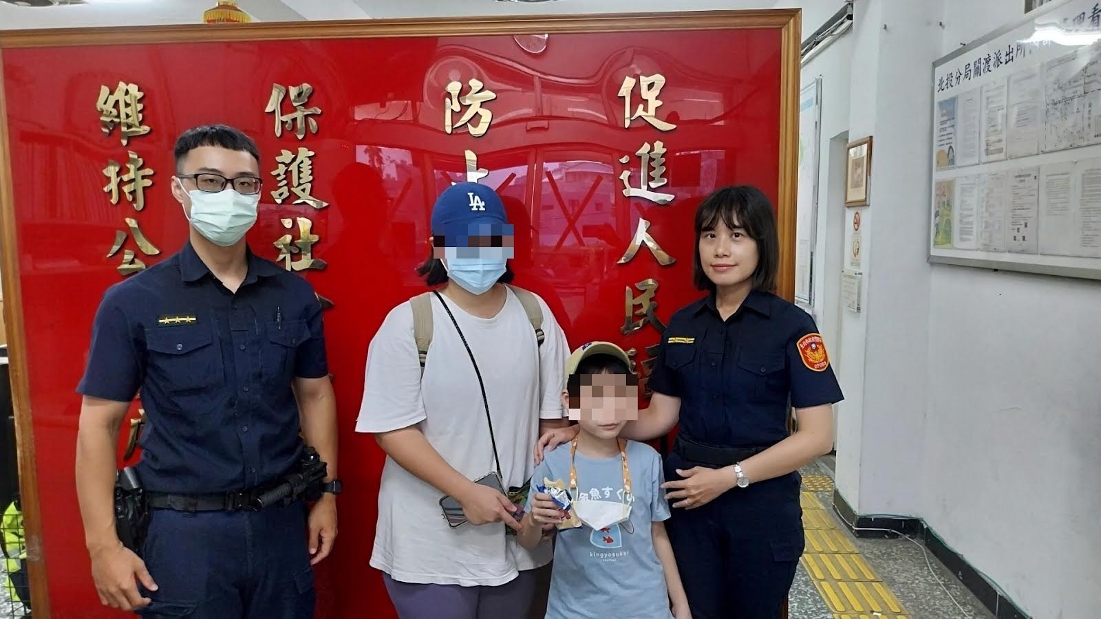 北投分局關渡派出所所長陳以雯及警員郭駿宏協助走失的男童與家人團聚。(記者薛秀蓮翻攝)