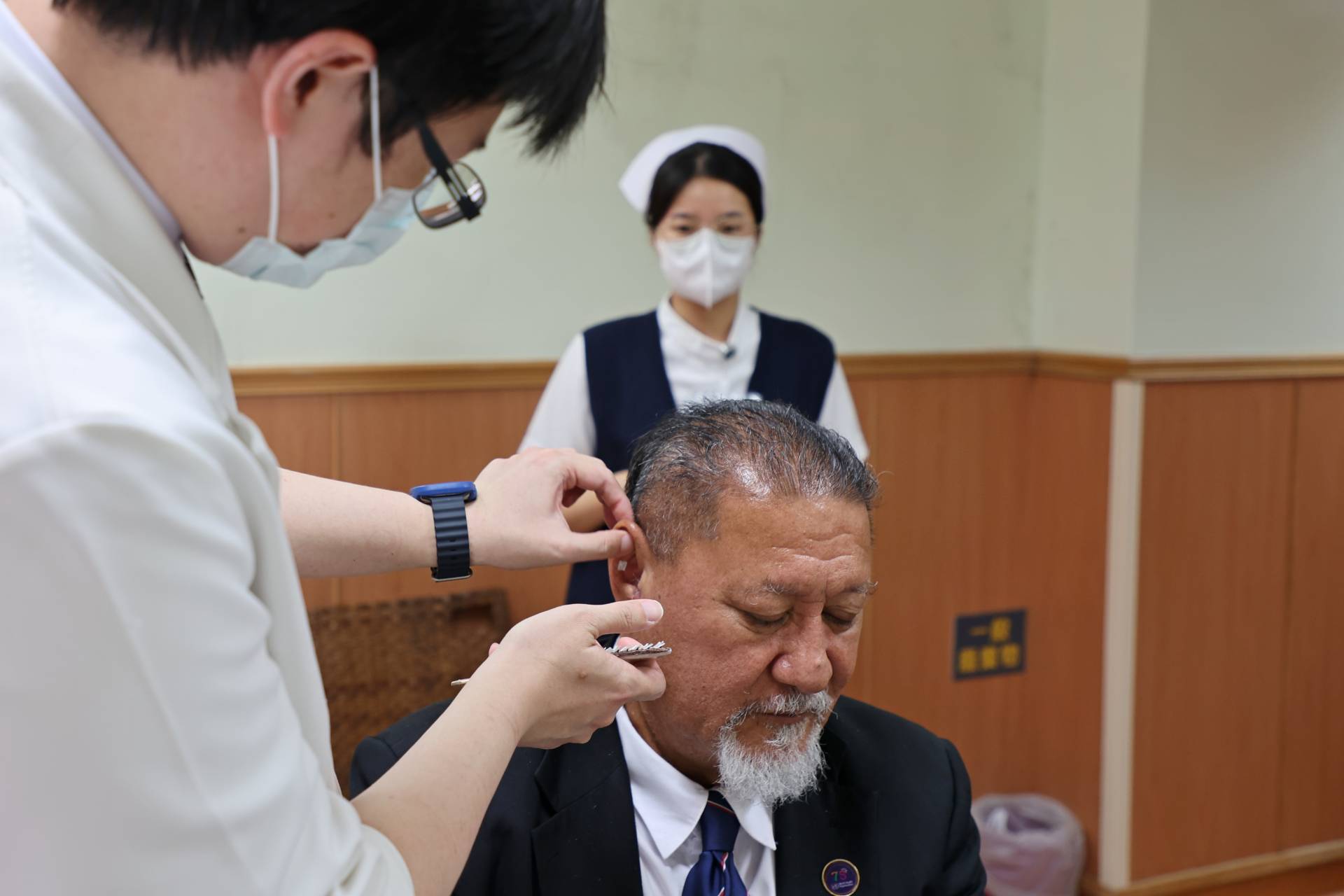 陳中奎醫師為Isaia Taape部長貼耳豆。