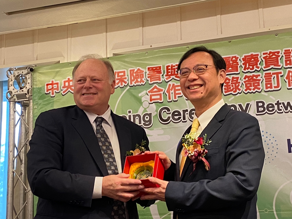 (右)健保署石崇良署長致贈禮物給(左)HIMSS總裁兼執行長Hal Wolf(記者黃楸玲/攝影)