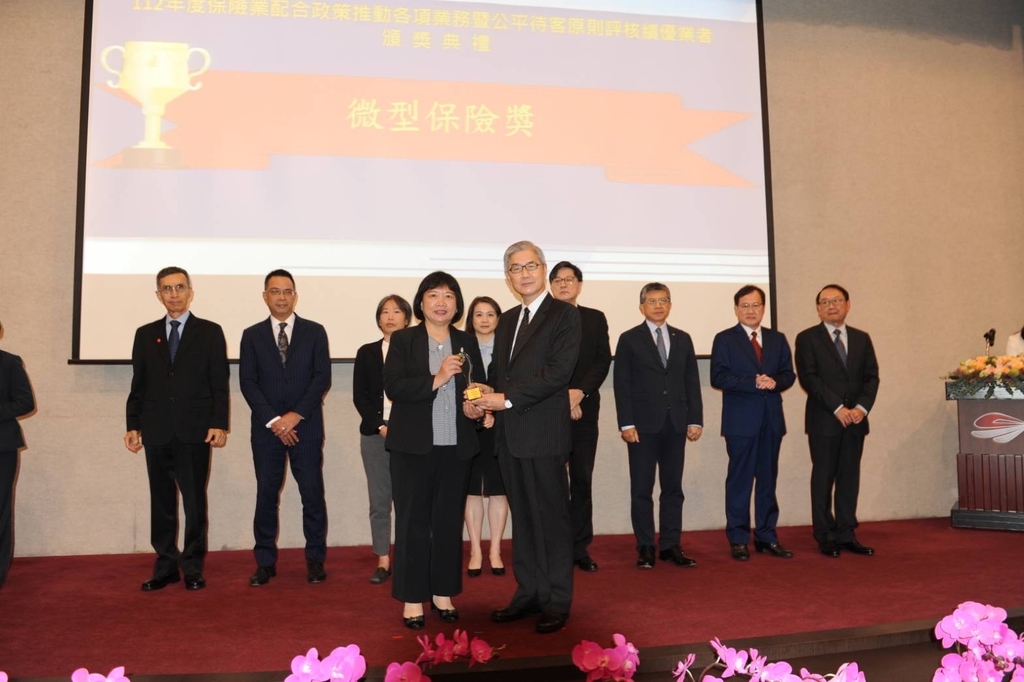 中華郵政獲頒「金管會112年度微型及小額終老保險競賽」3項殊榮肯定，由壽險處長簡詠涵（左）代表出席，接受金管會主委黃天牧（右）頒獎。（圖：中華郵政公司）