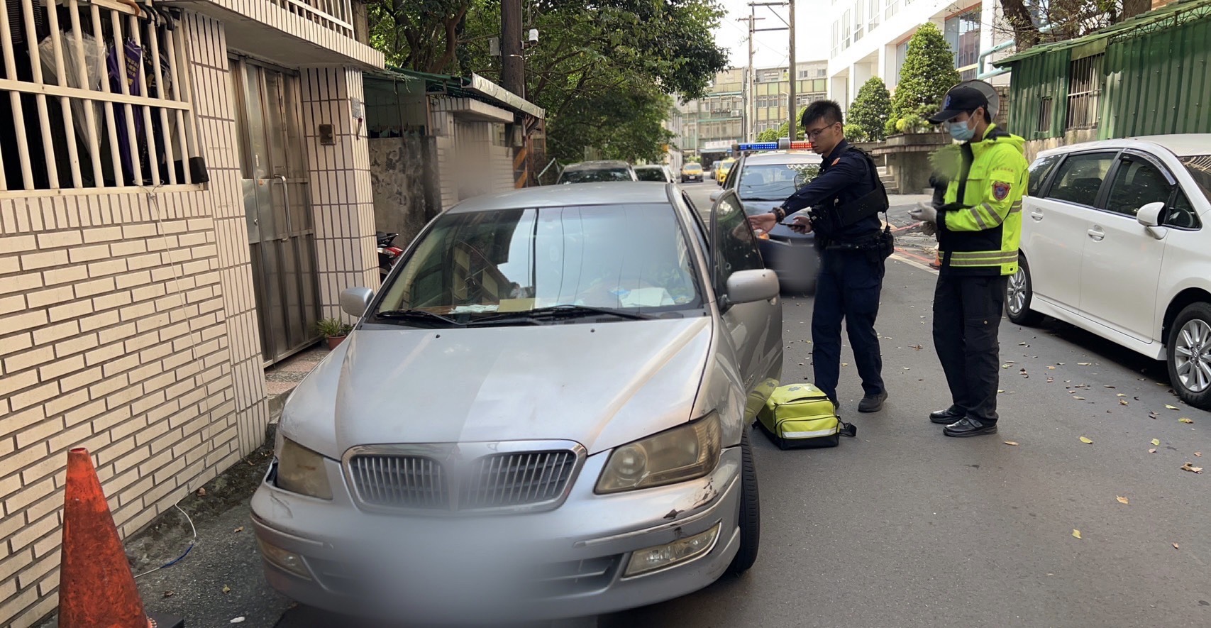 員警到場協助開啟車門,喚醒駕駛。(記者薛秀蓮翻攝)