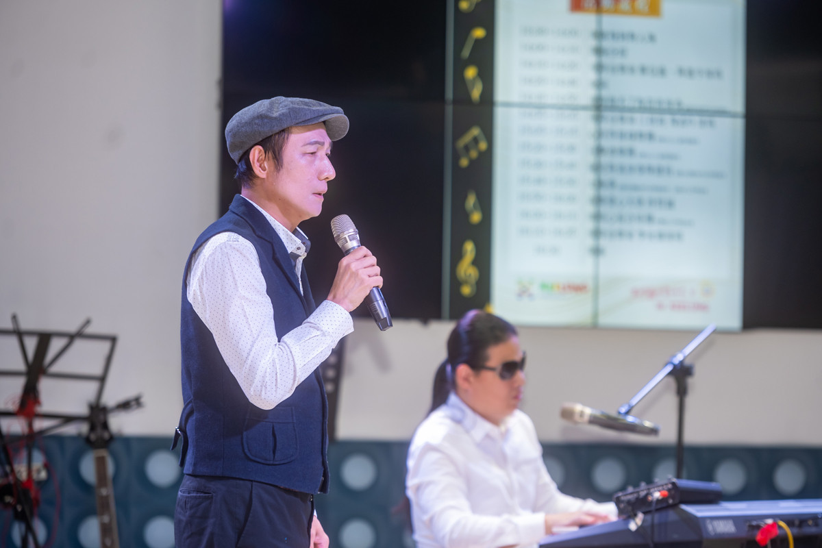 臺灣葡萄樹關懷協會鄭信盛秘書長與視障音樂家周建宇演唱。