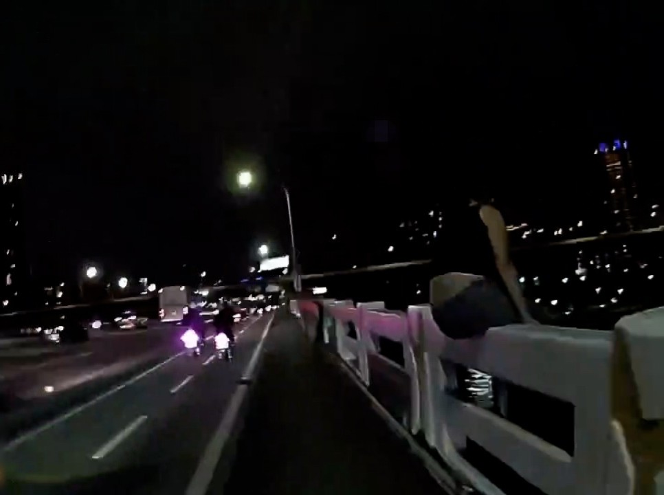 女子情緒激動跨坐在欄杆上。(記者宋紹誠翻攝)