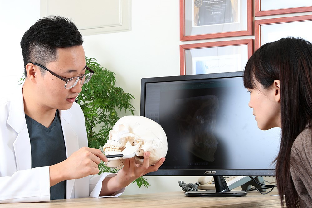 口腔顎面外科專科 張元瀚醫師向患者解說正顎手術原理。 （示意圖，非當事人）