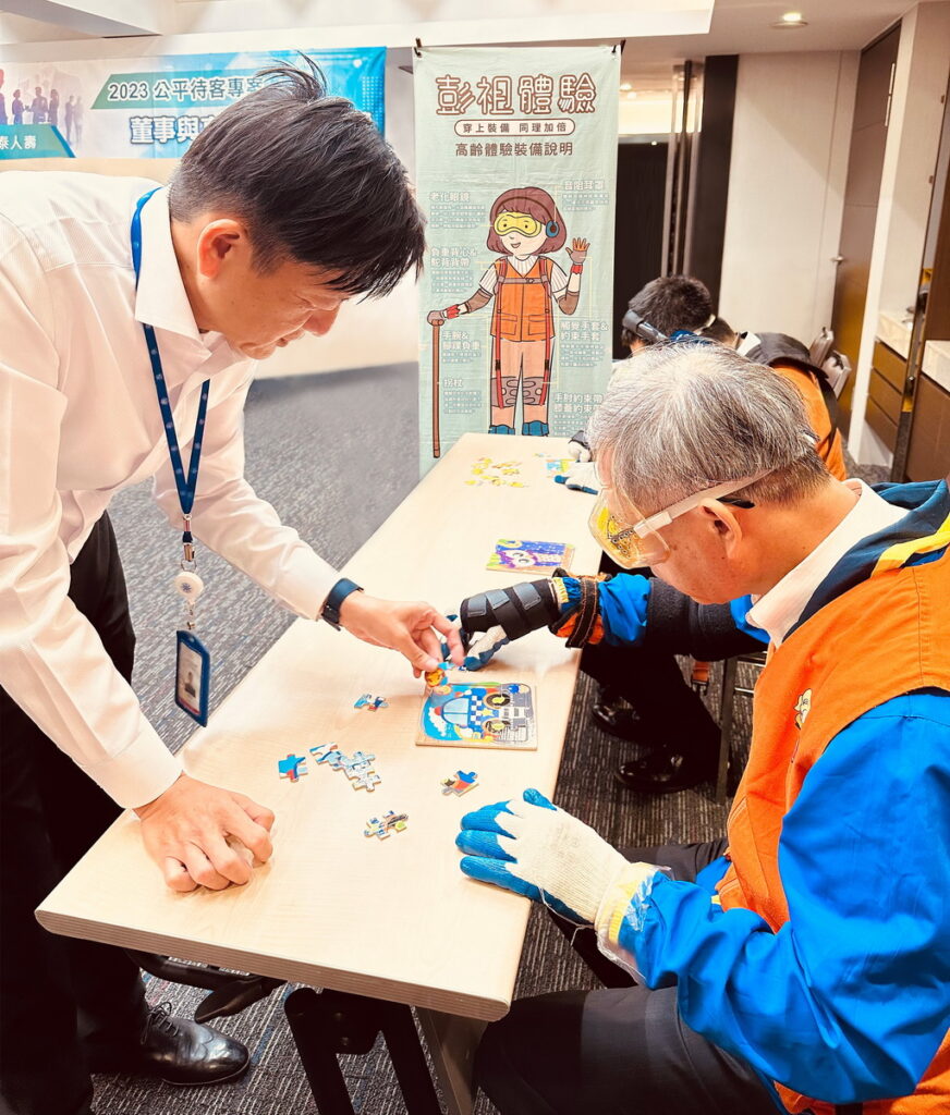 宏泰人壽李啓賢董事長(右)與邢開國董事(左)參與高齡模擬體驗課程,透過角色扮演共同完成小組任務,深刻體驗與高齡族群互動可能發生的困難與狀況。