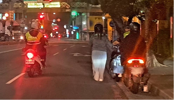 員警協助女子將機車停放至安全處。(記者宋紹誠翻攝)