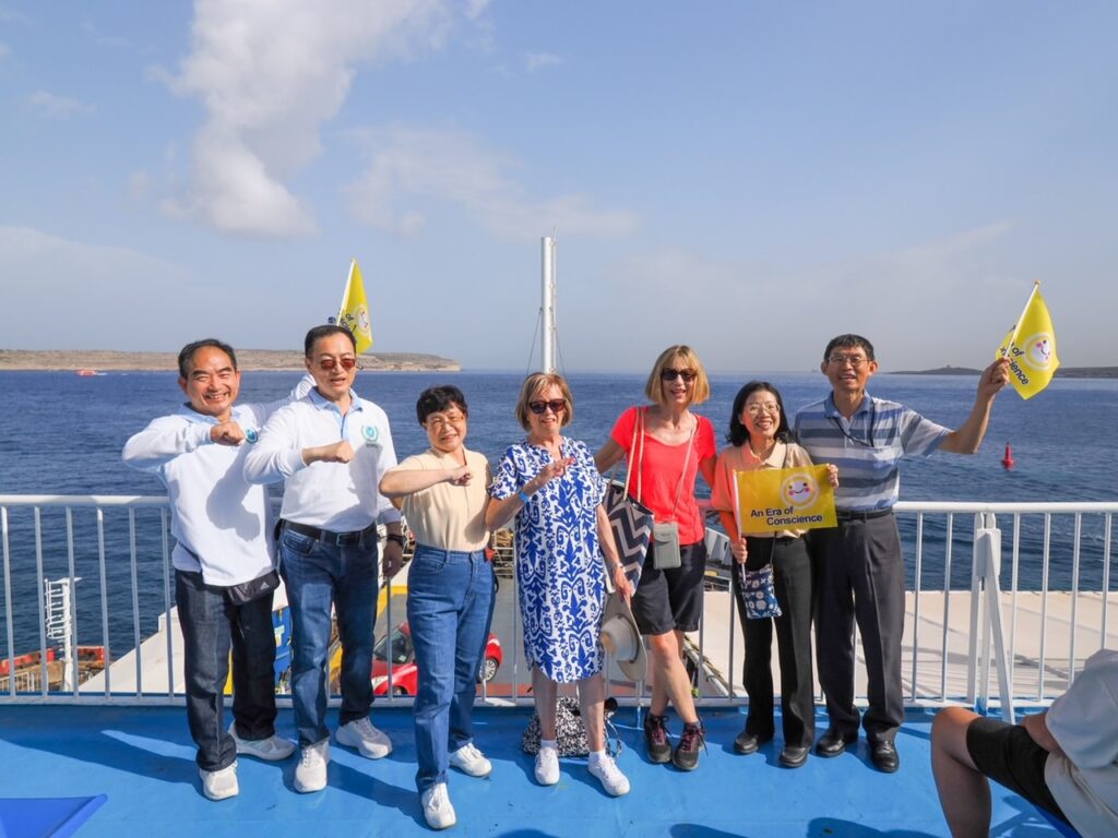 ▲前往戈佐島(Gozo)的渡船上兩位英國遊客主動受訪並連署後與親訪團合影。(記者李欣翻攝)