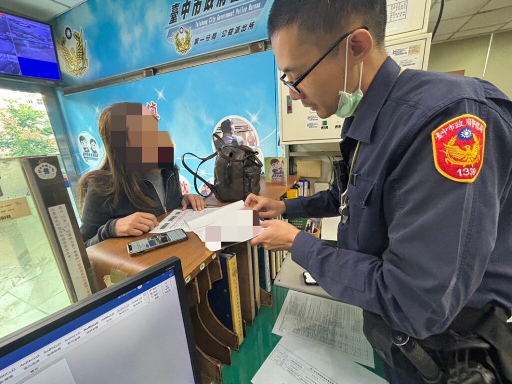 ▲圖說:公益所警員李文詳快速掃描文件,再以流利英文向外籍女安琪拉說明 (圖/台中市政府提供)
