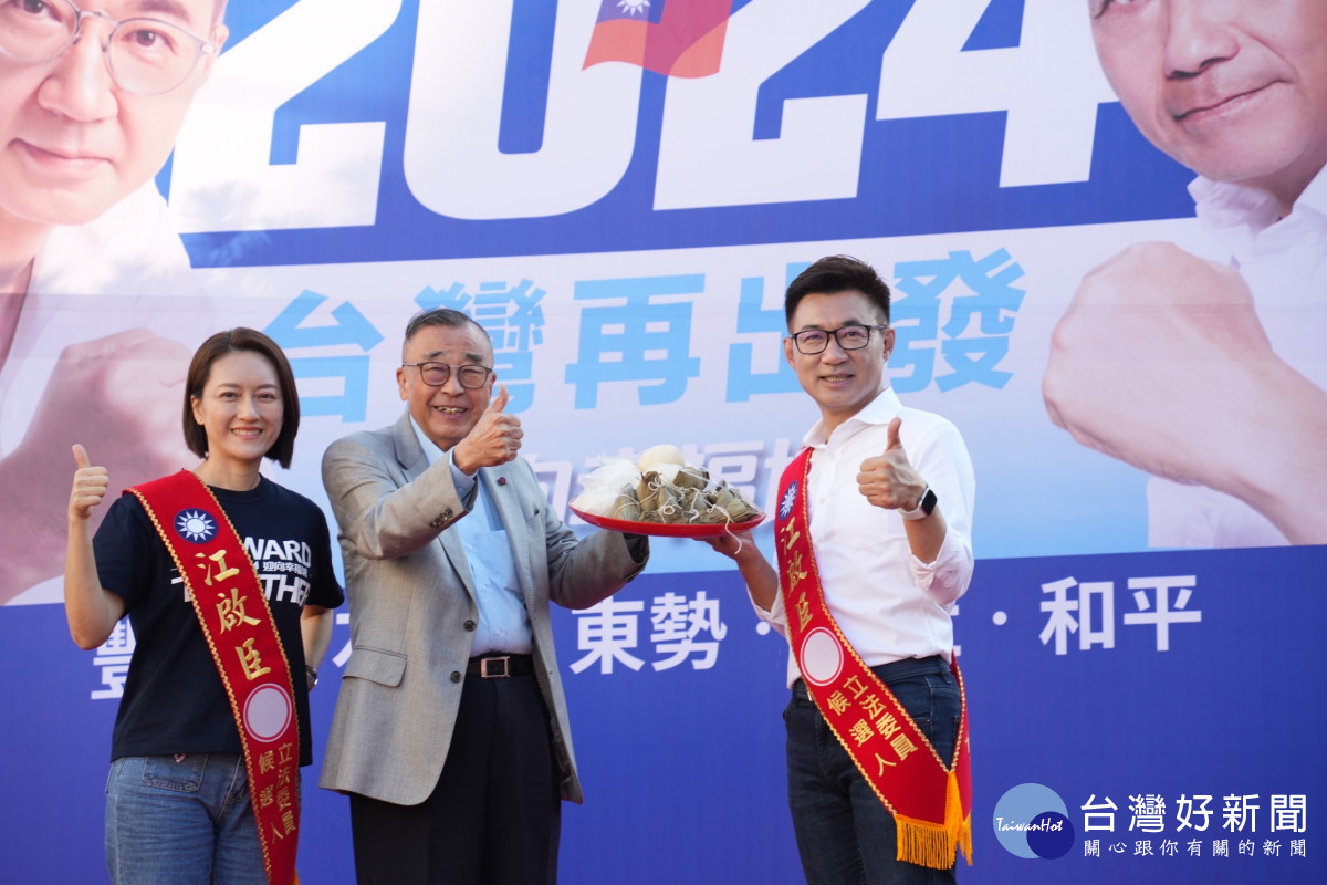 前總統府資政廖了以致贈江啟臣象徵包中的包子與粽子。