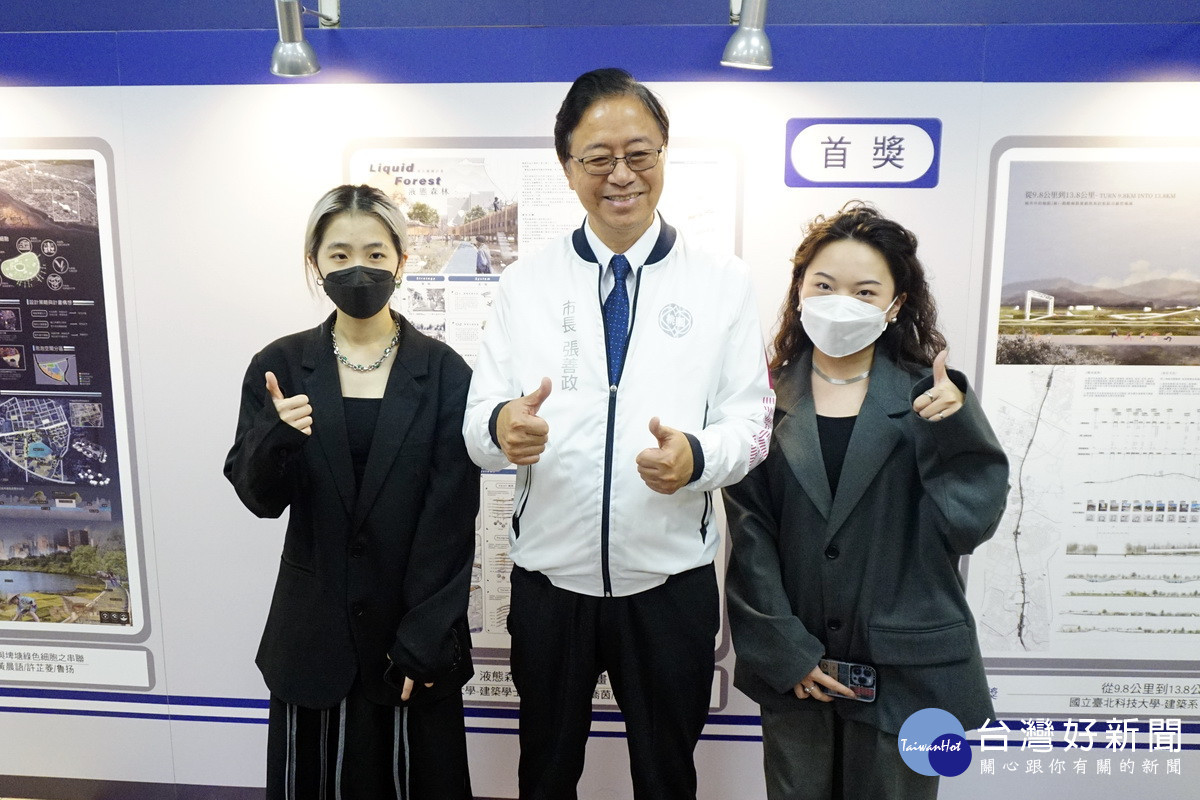 桃園市長張善政參觀「空間規劃組」首獎作品《液態森林》,與創作人逢甲大學建築系吳喬茵、廖翊妤合影。