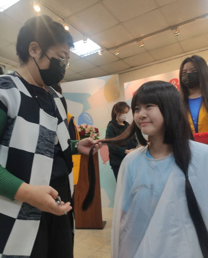 圖／從出生到現在14歲從未剪過短髮的8年級林采婕同學說，在媽媽的協助剪髮捐贈；一刀剪下雖然心痛不捨，但與癌友抗癌的過程相比是微不足道。（圖／福營國中提供）