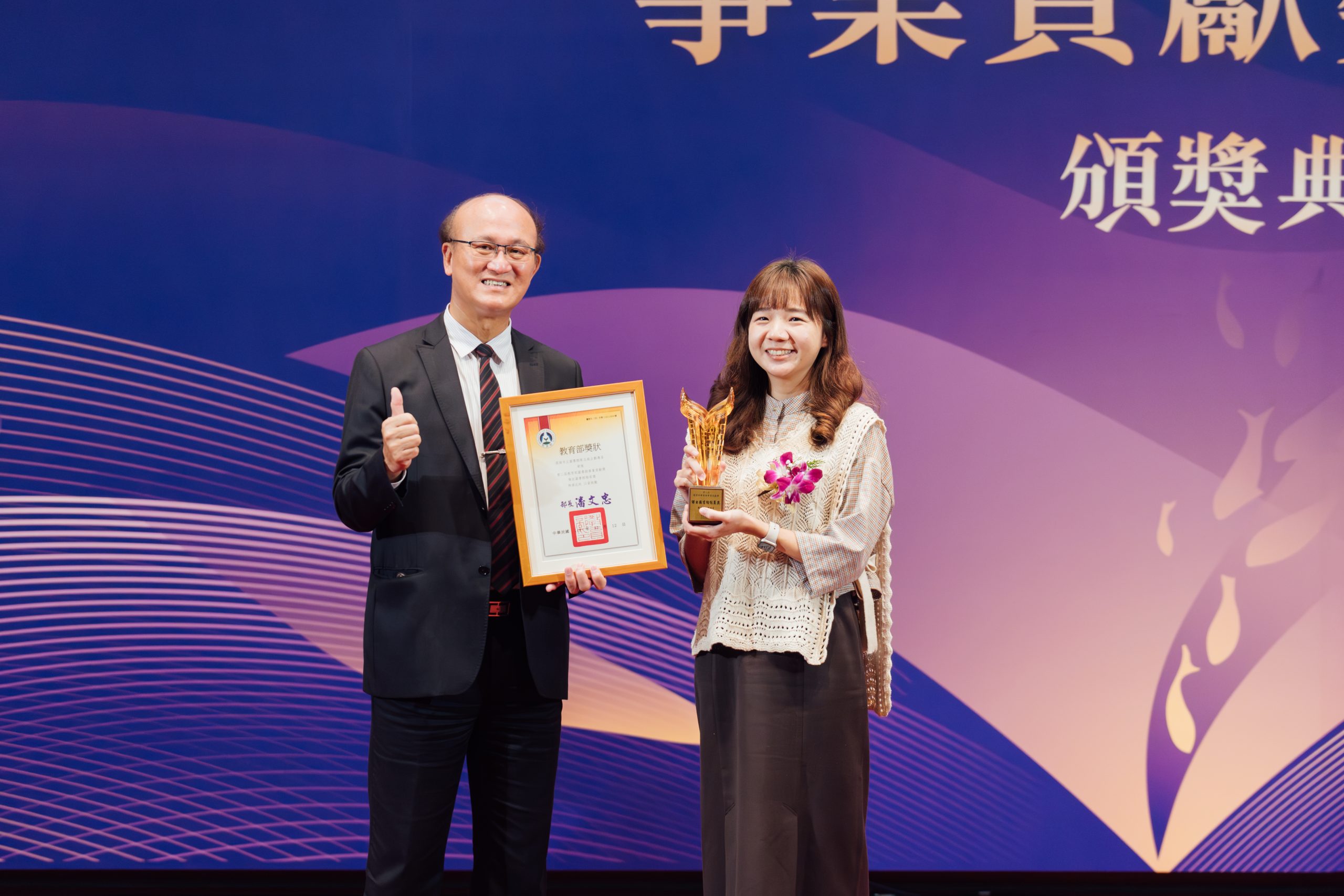 高市圖勇奪第二屆教育部圖書館事業貢獻獎雙獎項,教育部次長林騰蛟(左)頒發「傑出圖書館館員獎」給予高市圖企劃專員蔡玉庭(右)。(高市圖提供)