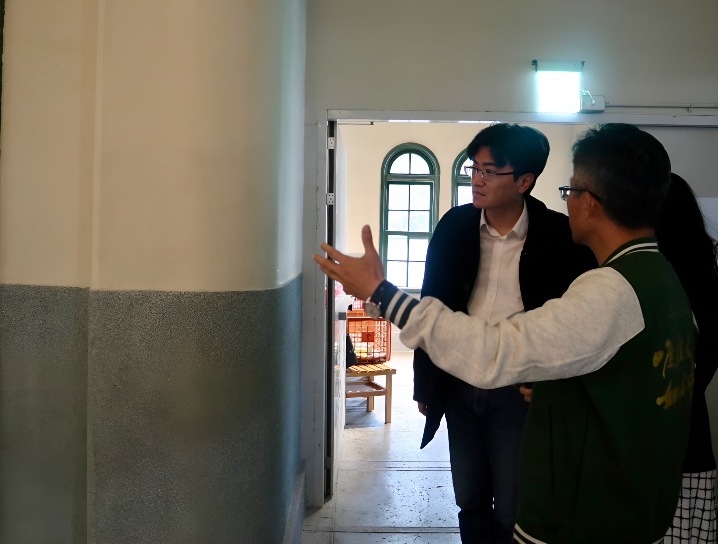 北一女中校長陳智源為一卡通公司總經理鄭鎧尹導覽光復樓修繕完工成果。(一卡通提供)