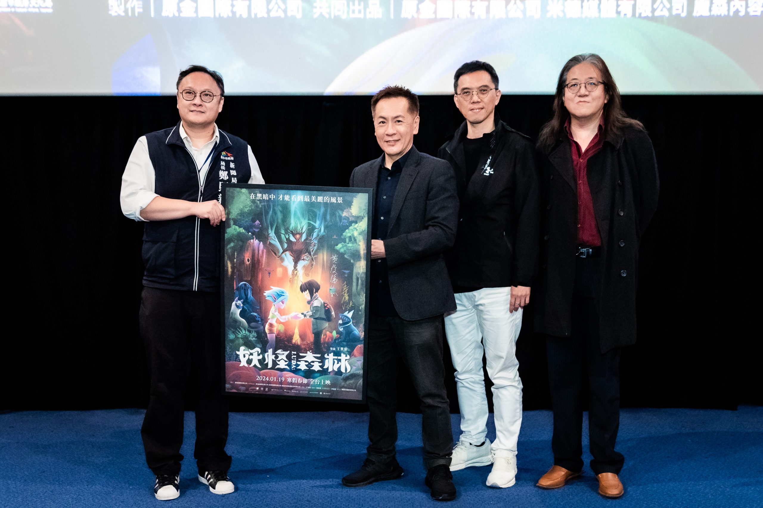《妖怪森林》台中首映導演王世偉(左二至左四)、監製黃俊傑及聲音統籌胡育彰,致贈電影簽名海報給新聞局長鄭照新(左一)。(新聞局提供)