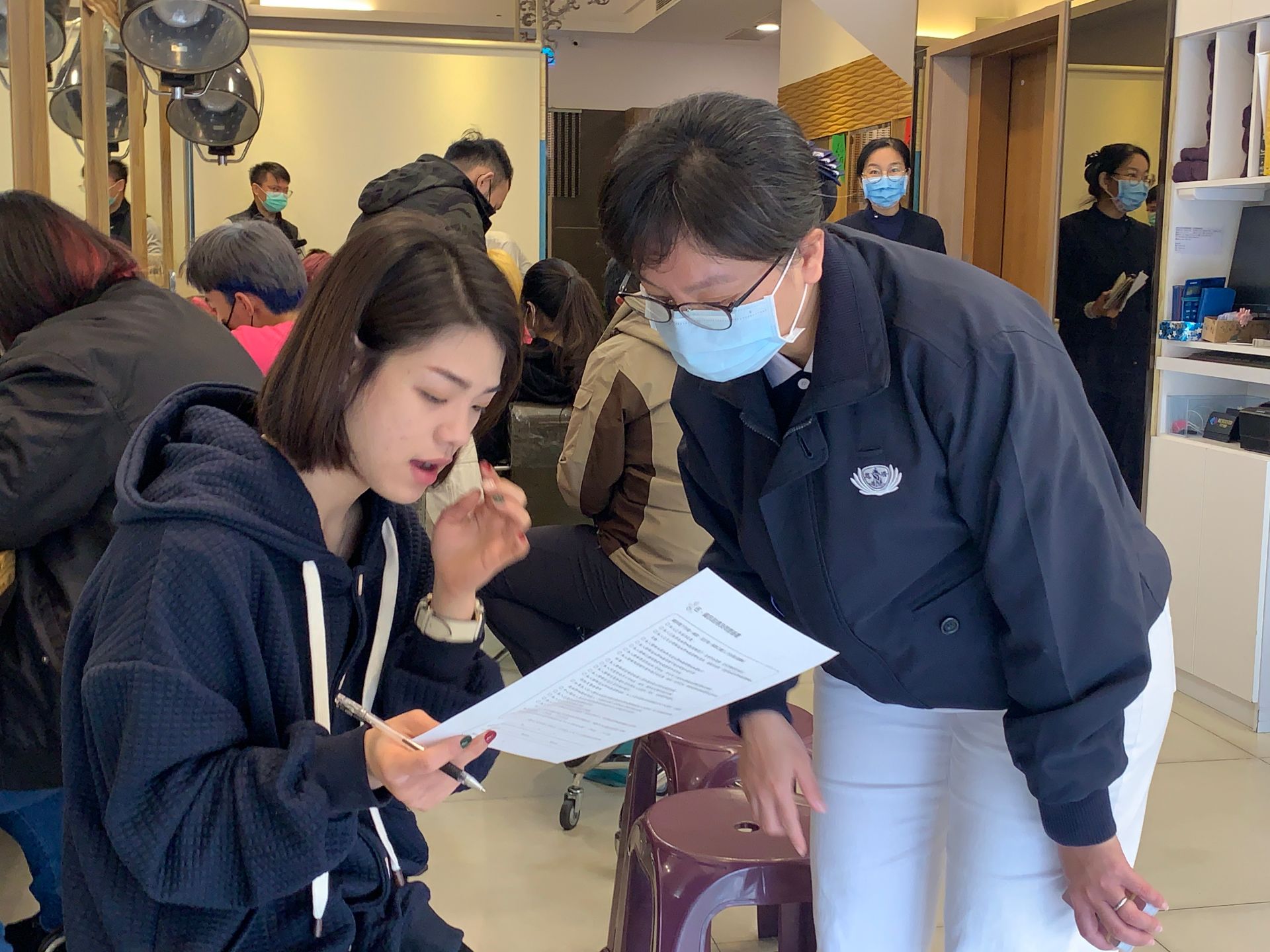 慈濟志工在曼都髮廊花蓮店協助與解說造血幹細胞志願捐贈建檔同意書的填寫，隨時提供服務。