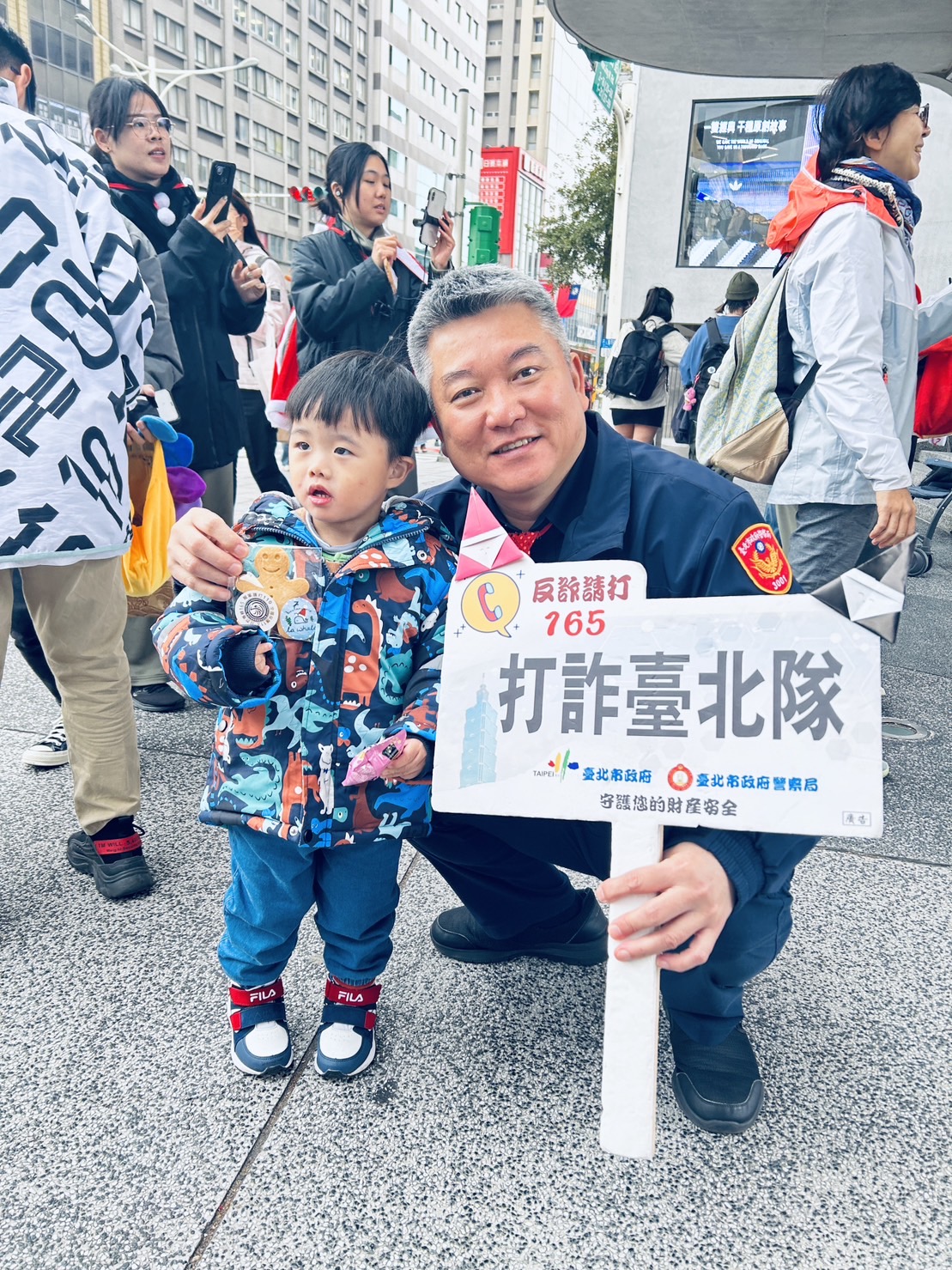 中山分局分局長陳金城與小朋友們共同傳遞聖誕的祝福,提醒他們做明智的選擇,保護自己。(記者薛秀蓮翻攝)
