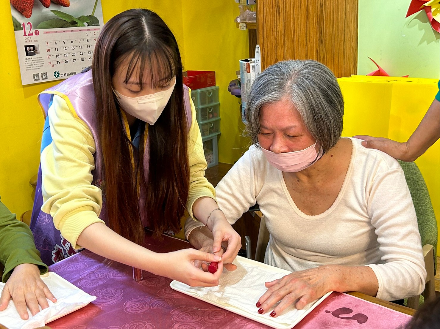 樹 人 家 商 美 容 科 學 生 細 心 地 為 長 者 塗 上 指 甲 油 , 並 隨 時 留 意 長 者 的 需 求 , 讓 長 者 感 受 到 細 微 的 照 顧 , 展 現 出 青 春 自 信 的 笑 容 。