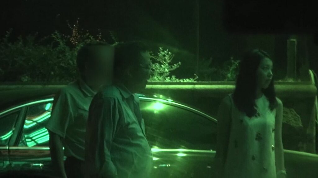 影片4截圖:眾人在停車場說話，女子在旁站立，女子長相清秀（影片來源:爆料信)