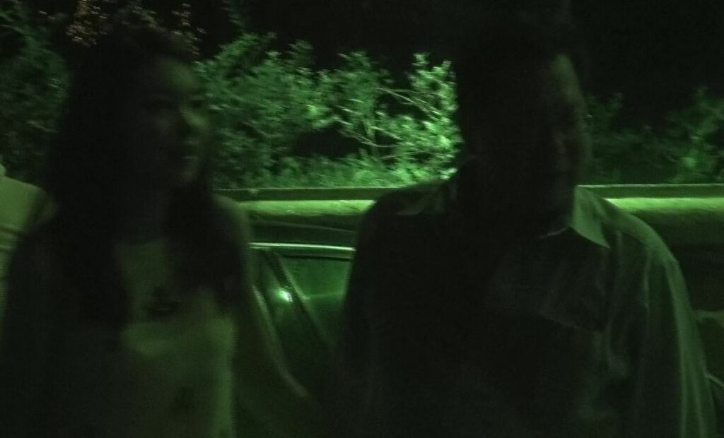 男子與女子在停車場等車，除了擁抱，亦有短暫牽手動作