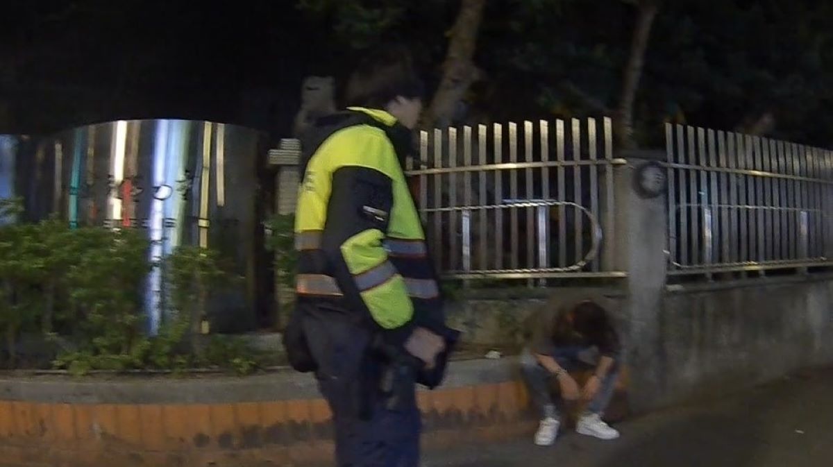 方男由員警協助攙扶至一旁臺階休息。(記者薛秀蓮翻攝)