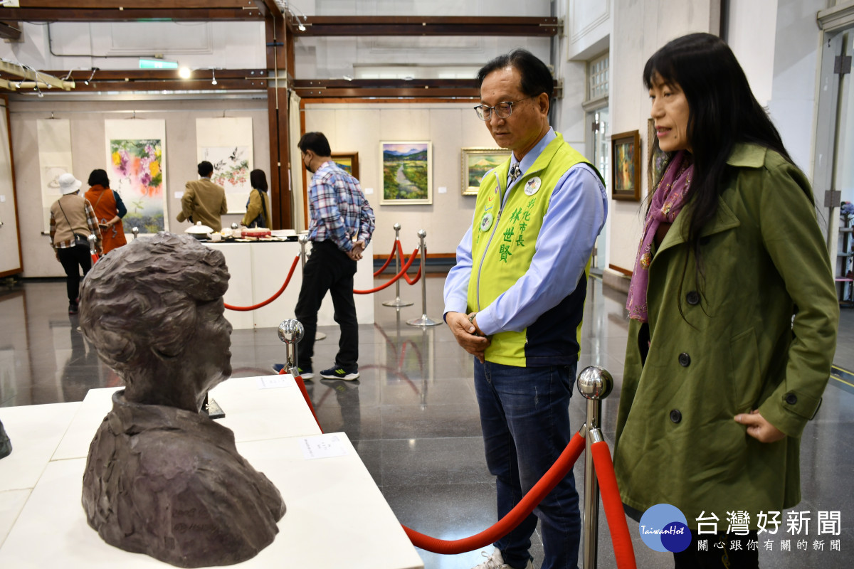 太陽文化藝術協會理事長李雪蘭向林世賢市長解說會員聯展作品。圖／記者鄧富珍翻攝