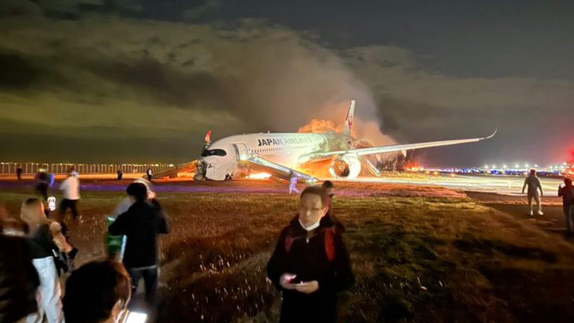 一名外國乘客2日自JL516班機成功逃生,在安全地點回頭拍下班機失火照片。翻攝@wmanzione「X」社群平台