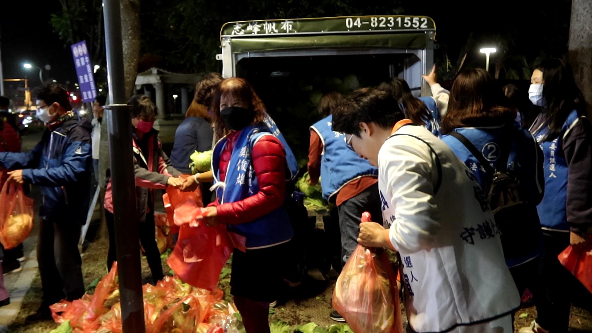 ▲高麗菜產量過剩，價格急跌，田尾公路花園協會理事長劉漢欽主動出手，自掏腰包收購了大批高麗菜，並邀請侯友宜及鄭俊雄聯合競選總部志工，在田尾公路花園夜市廣場免費分發給民眾。（記者張溎壕攝）