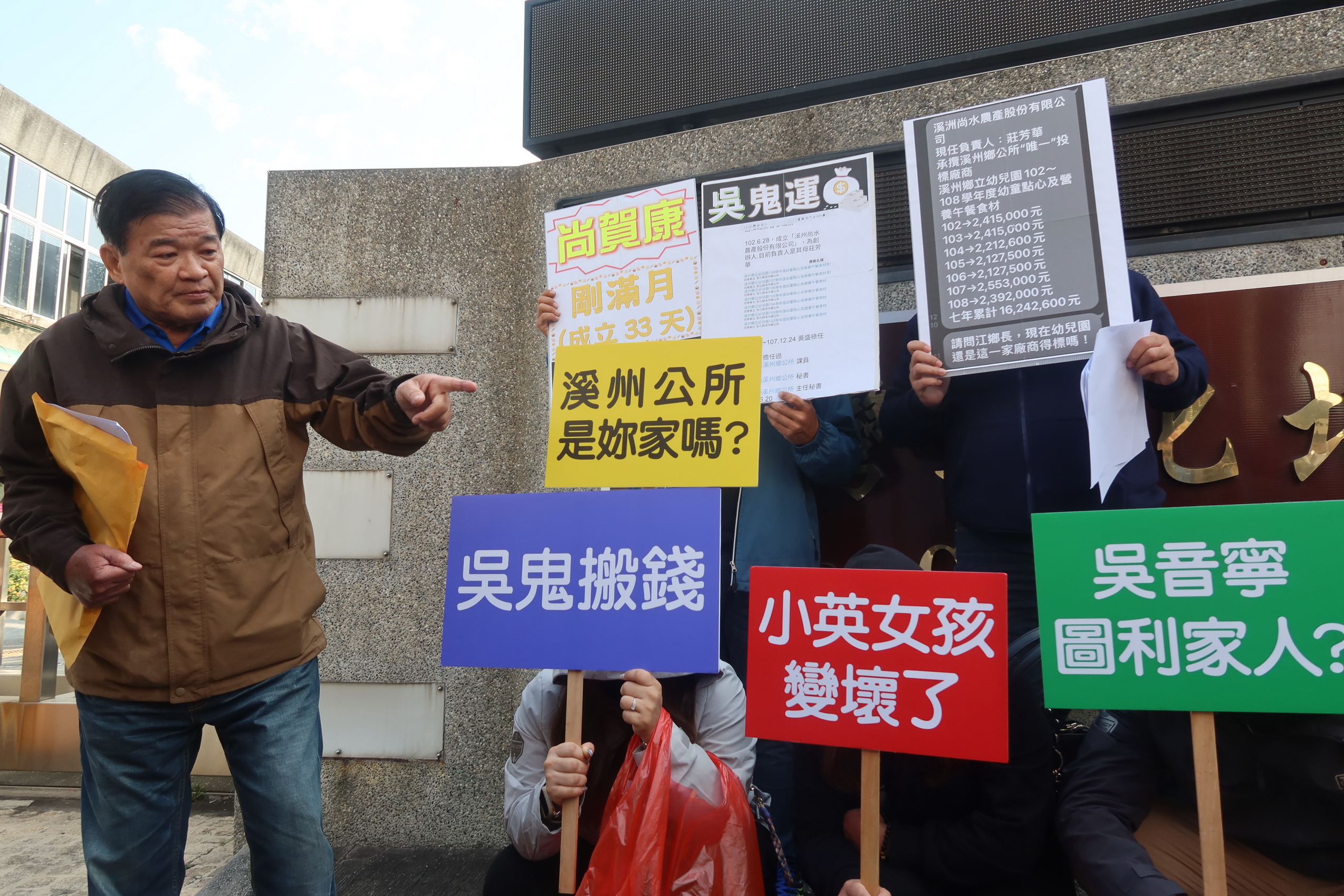 ▲彰化前民進黨資深黨員林斯明手拿「吳鬼搬運」立牌，前往彰化地檢署按鈴控告第三選區立委候選人吳音寧等三人觸犯貪汙治罪條例圖利罪。（記者張溎壕攝）