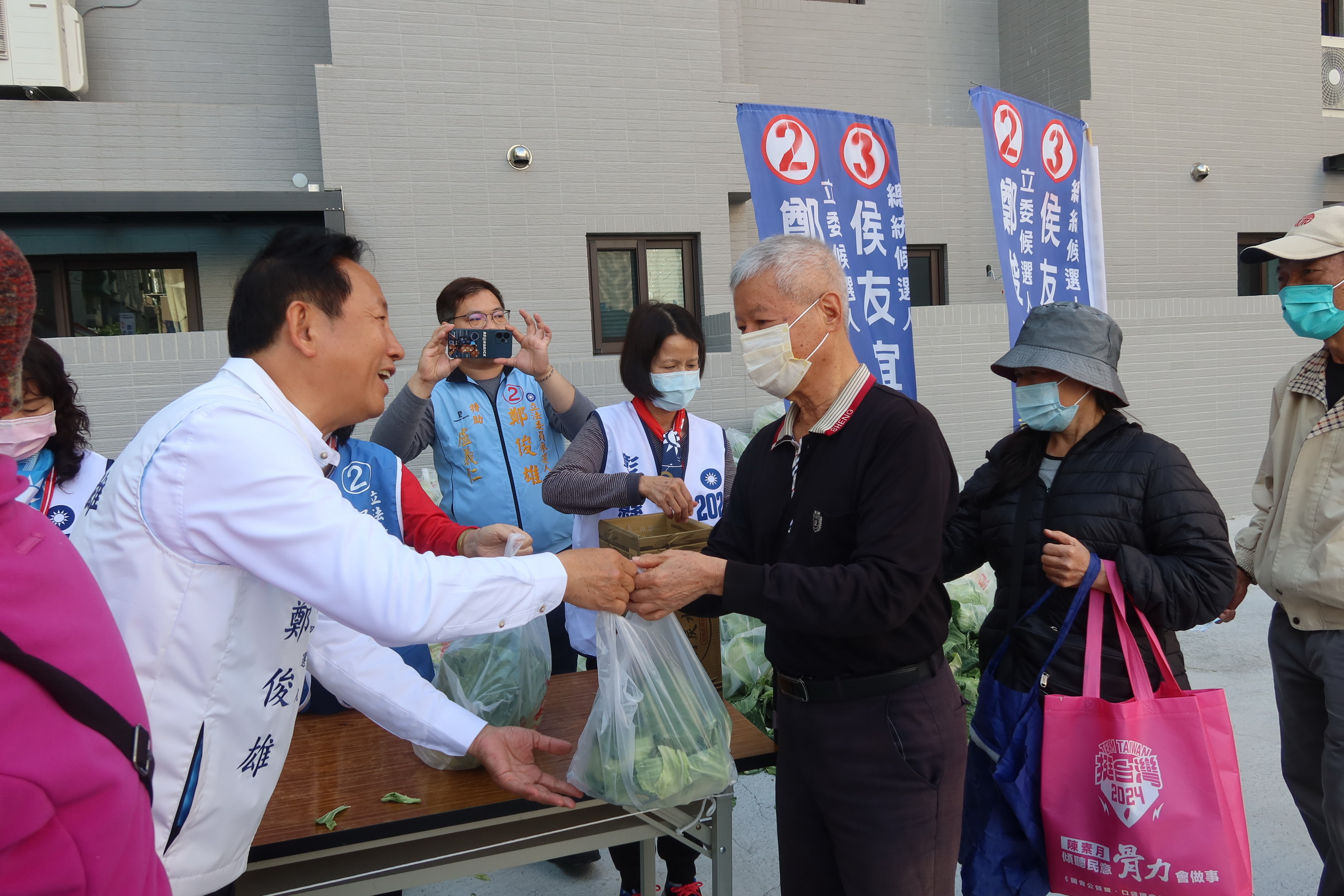 ▲彰化第四選區立委候選人鄭俊雄在競選總部發起「送菜迎侯康‧民生有靠山」活動，吸引許多民眾拿著發票排隊換高麗菜。（記者張溎壕攝）
