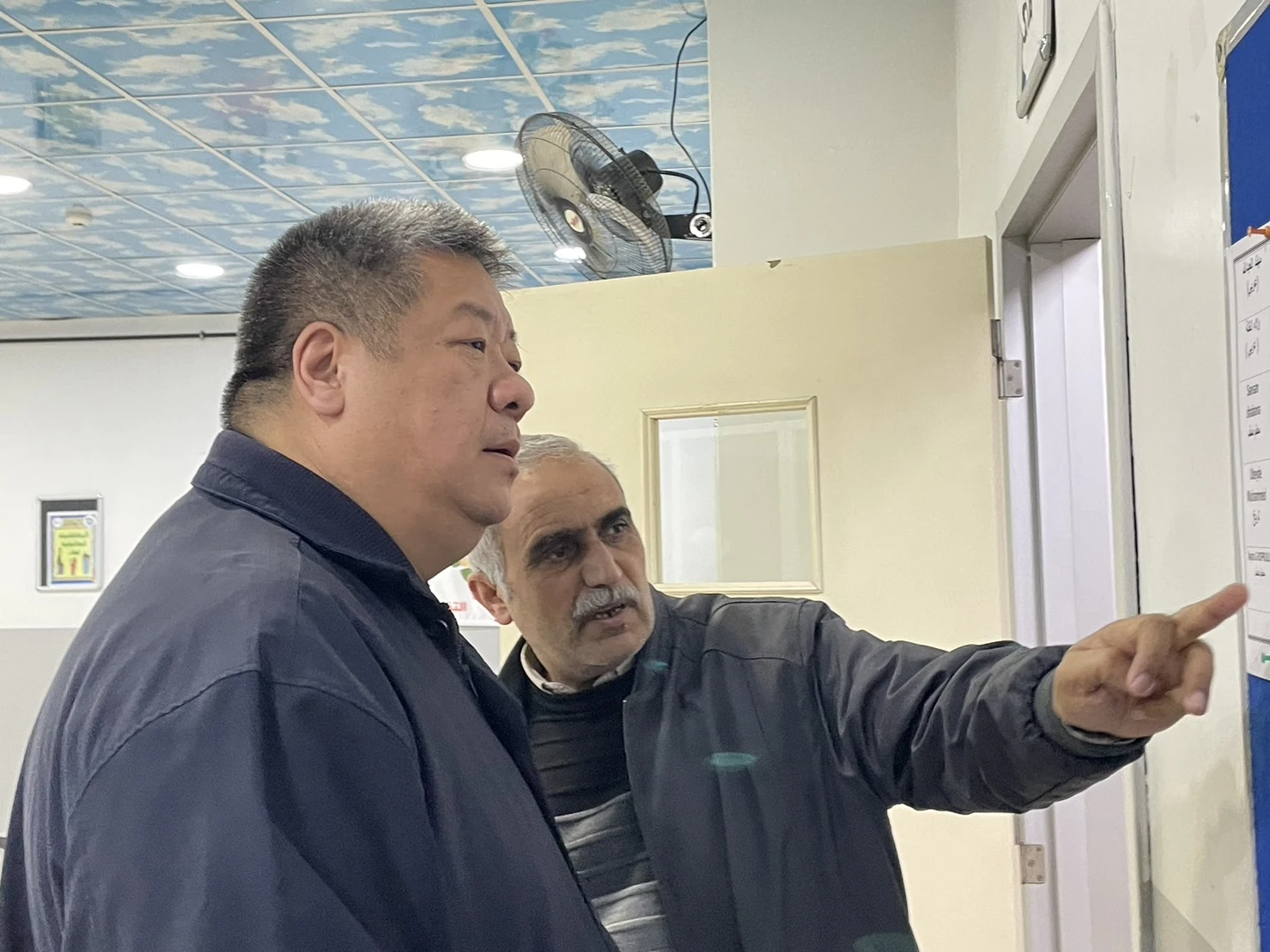 慈濟志工胡光中(左)指出,選擇老師的標準包括具有土耳其籍,不論是土耳其人或取得土耳其國籍的敘利亞人,老師必須取得土耳其政府核准的同等學歷認證。