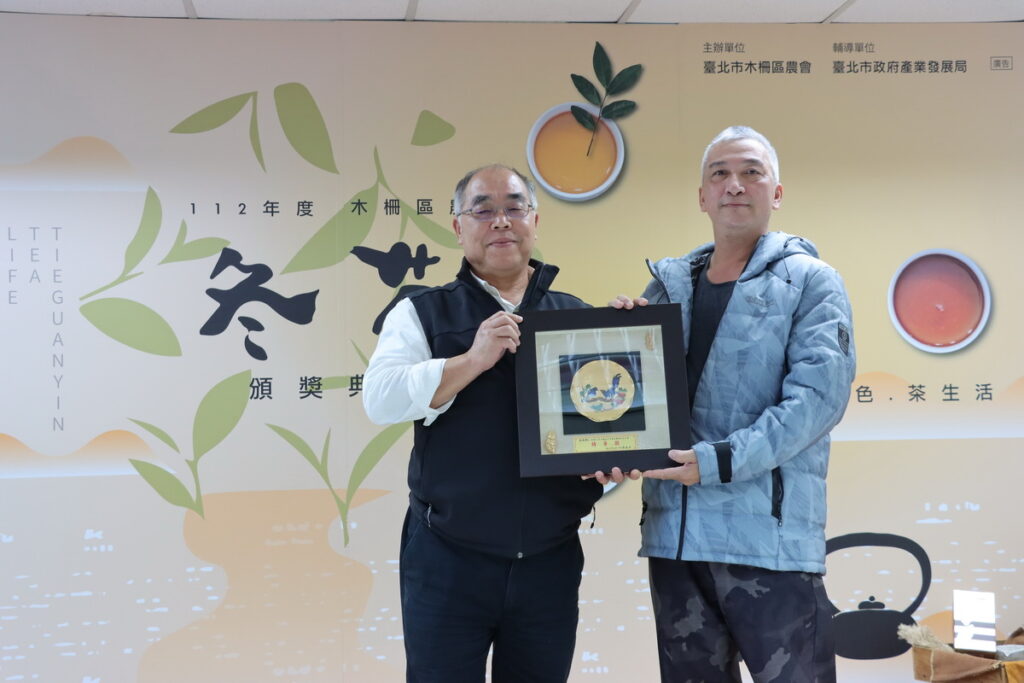 臺北市政府產業局劉永修簡任技正頒發市府獎牌予112年木柵冬茶特等獎得主。
