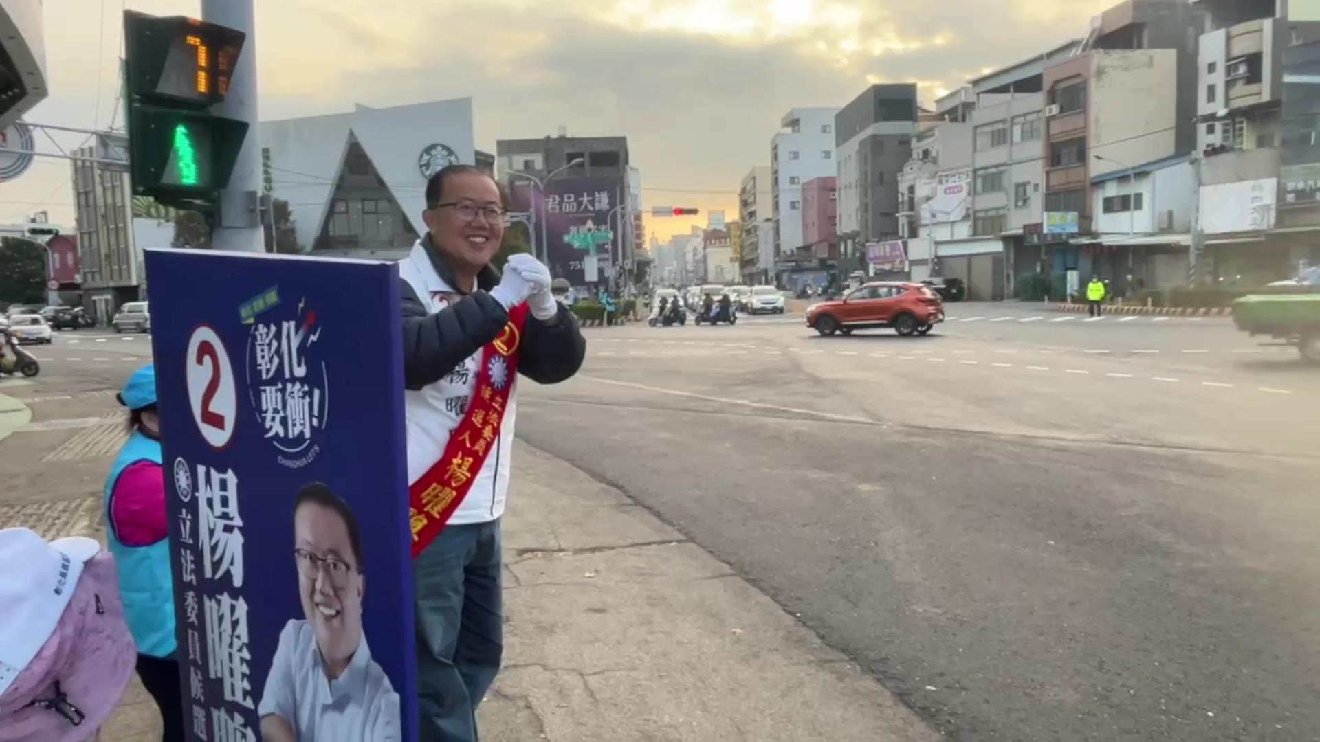 ▲彰化縣第二選區立法委員候選人楊曜聰不畏寒風，佇立在各主要幹道街口揮手拜票，楊曜聰再次強調，他所發佈的相關資訊都是可以公開查詢的資料，絕非憑空捏造。（記者張溎壕攝）
