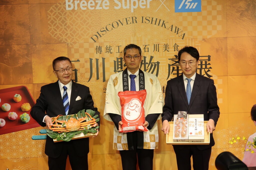 日本石川展首度登台，(左起)微風集團常董 岡一郎、日本石川縣農林水產部參事 吉田健一、日本交流協會副代表 服部崇，手持石川縣招牌物產合照為活動揭開序幕。