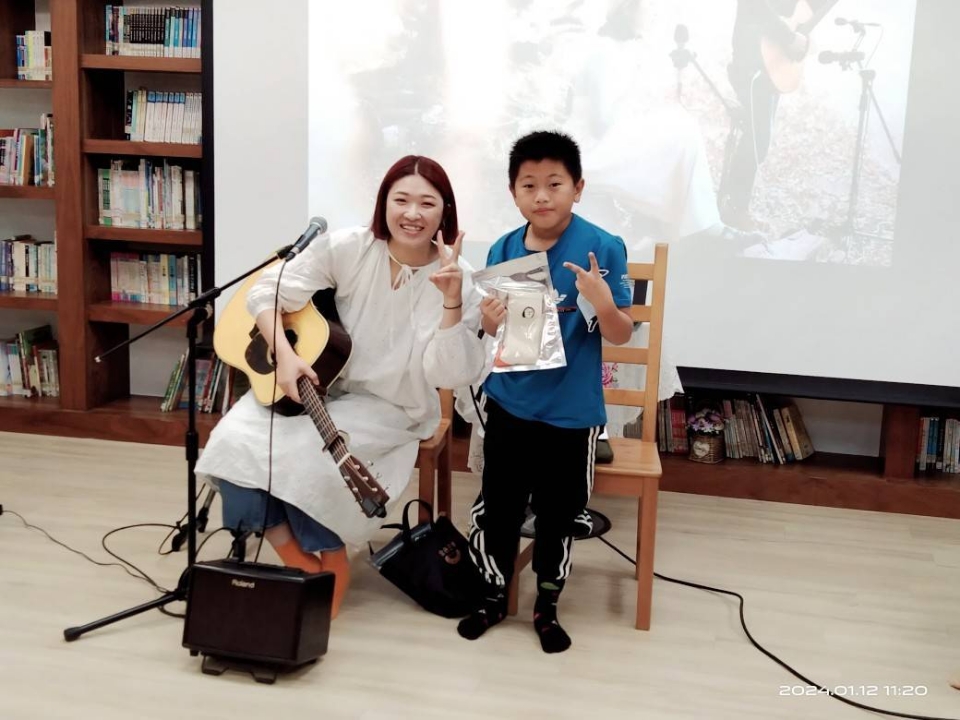 ▲邱淑蟬與小小學弟妹面對面，分享榮耀與歌曲。（高雄市政府教育局提供）