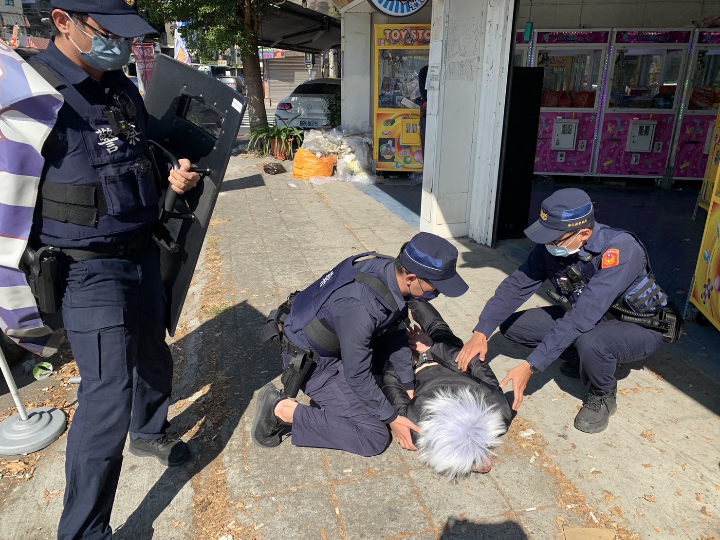 ▲彰化警分局辦理金融機構防搶演練，男女員警扮演《咒術迴戰》中的五條悟、薔薇，以逼真的動作和情境模擬歹徒搶劫銀行，情節逼真，讓現場民眾嚇了一跳。（記者張溎壕攝）