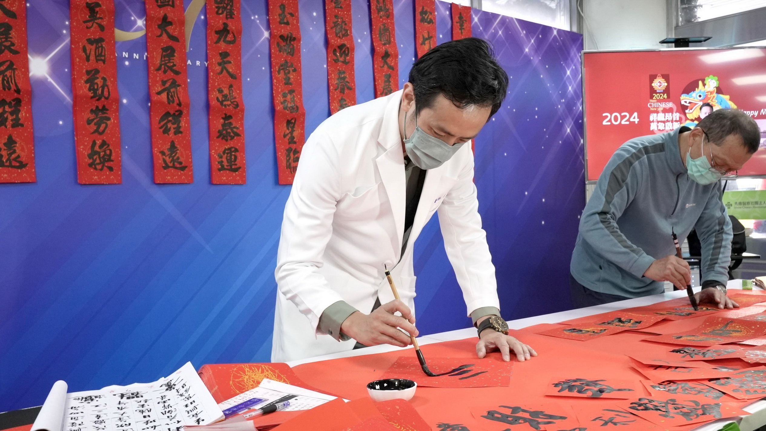 ▲迎接農曆新年，彰化秀傳醫院舉辦春聯揮毫送民眾活動，現場民眾爭相索取院長寫的春聯，冰冷的醫院增添更多的喜慶氣氛。（記者張溎壕攝）
