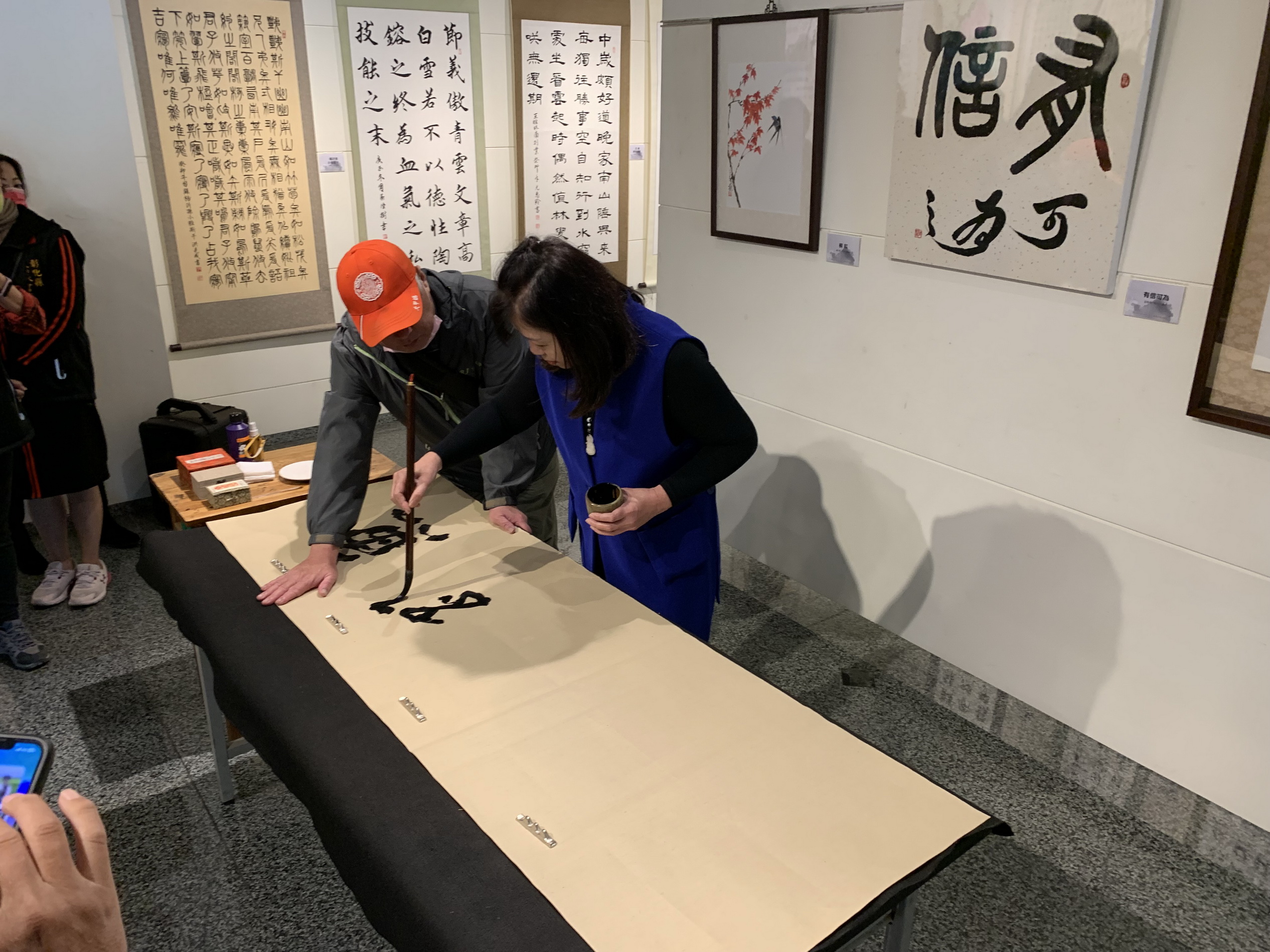 ▲君承書畫協會指導老師林俞君於開幕式現場揮毫。（頂新和德文教基金會提供）